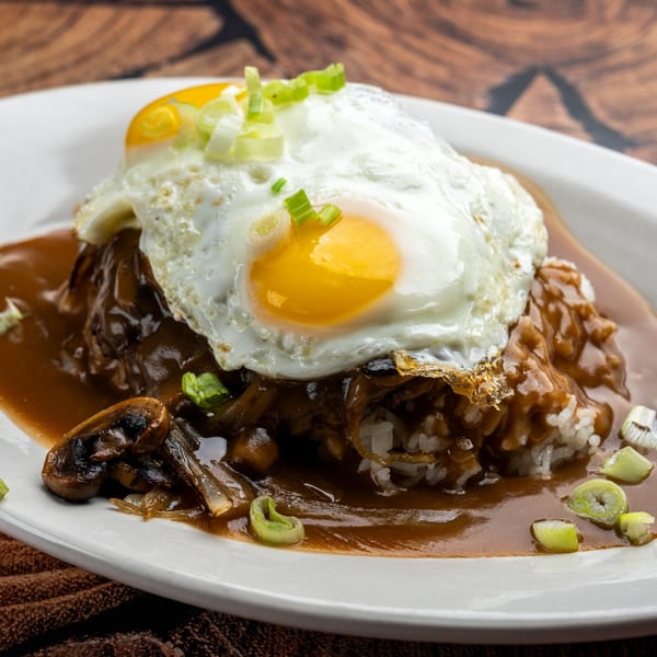 Krazy Kooters' Loco Moco with two fried eggs, gravy, mushrooms, and green onions on white rice.